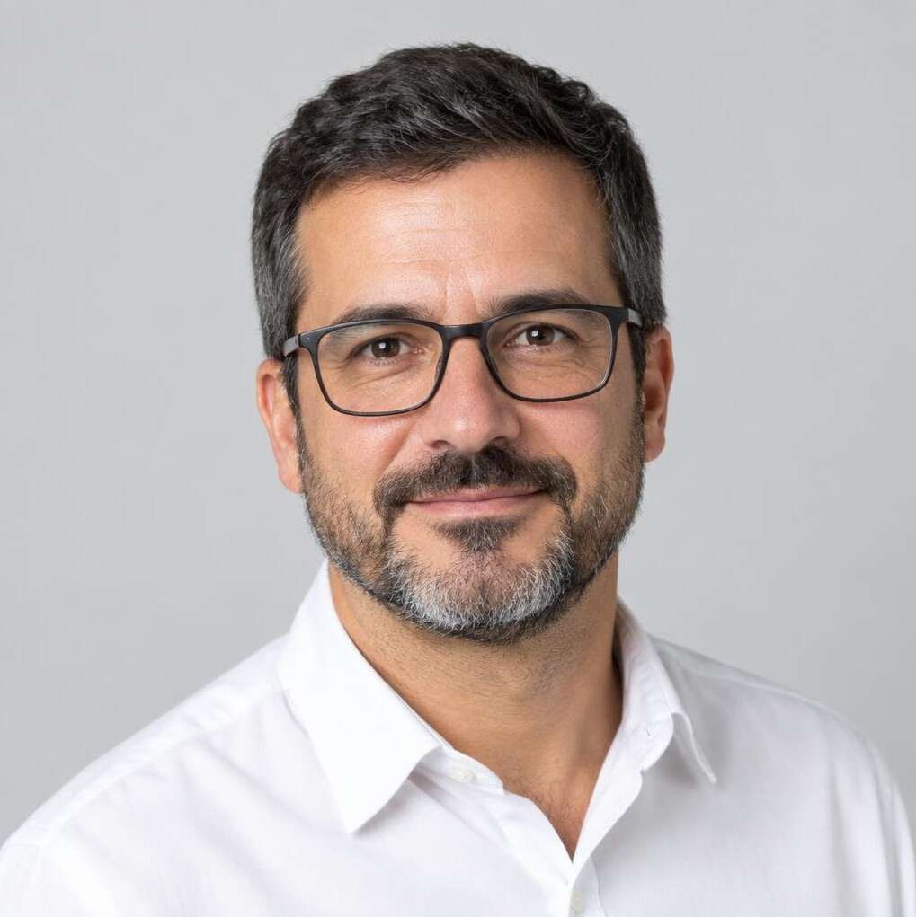 Studio portrait of a Portuguese man editor with glasses and a beard